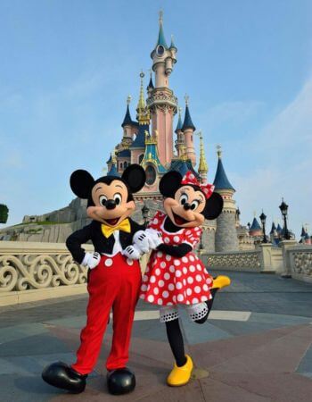 Mickey Mouse y Minnie Mouse posando frente al Castillo de Cenicienta en Magic Kingdom en Orlando, Florida. - Real Family Vacation: Servicios de Viaje en Orlando.